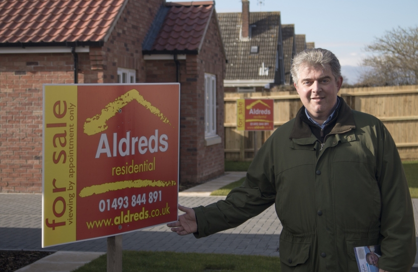 Brandon Lewis with house for sale sign
