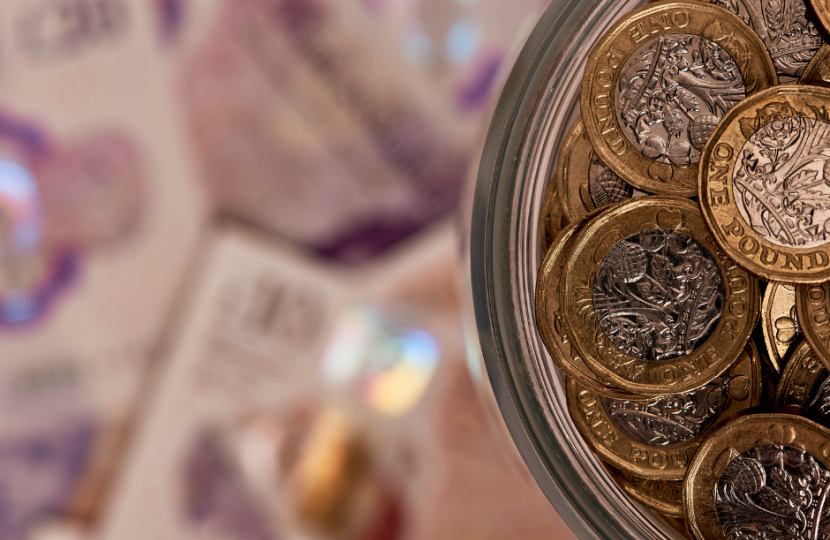 Close up of pound coins with £20 notes in background