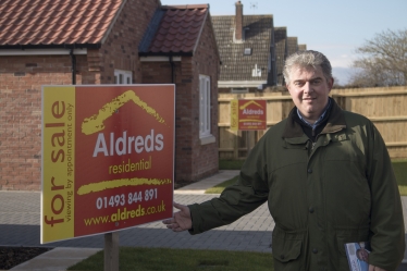 Brandon Lewis with house for sale sign
